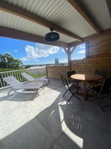 een terras met een tafel en stoelen op een dak bij O'Morne in Sainte-Anne