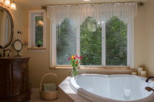 baño con bañera grande y ventana en A Hidden Haven Cottages en Port Angeles