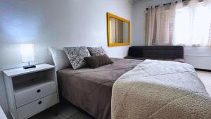 ein kleines Schlafzimmer mit einem Bett und einer Couch in der Unterkunft Apartamento no Centro de Gramado, 700 m da Rua Coberta in Gramado