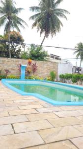 a swimming pool in a backyard with palm trees at Pousada Rancho Maragogi Pisicinas in Maragogi