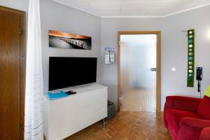 a living room with a television on a white dresser at Ferienappartment Becker Zentrum in Lauterbach