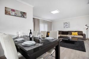 a living room with a dining table with white chairs at Villa Mila Piscina e Jacuzzi in Salir de Matos