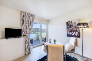 a living room with a table and a large window at Rheinapartment Dependance 8 in Bad Hönningen