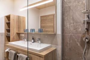 a bathroom with a sink and a glass shower at Hotel zum Schwanen - Appartement 6 in Pflach +18 photos
