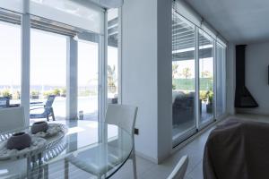 a glass dining room with a glass table and chairs at V196 Villa Brisa in Son Bou