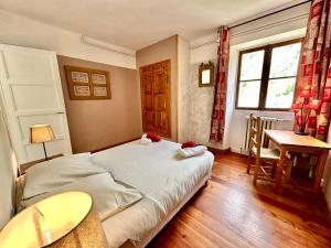 une chambre avec un lit, une table et un bureau dans l'établissement Cemilia Chalet l'étoile des cîmes, à Ristolas