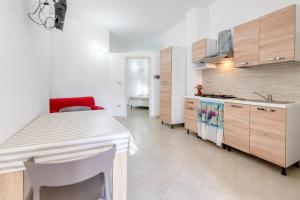 a kitchen with a white table and a red chair at Villa Bludea - Salento in Torre Lapillo