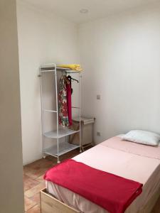 a bedroom with a bed with a red blanket and a shelf at Consciência Viva in Encarnação