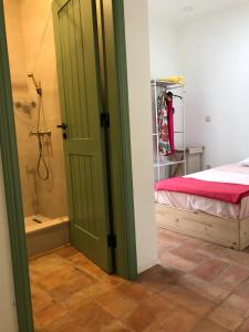 a bathroom with a shower and a bed and a door at Consciência Viva in Encarnação