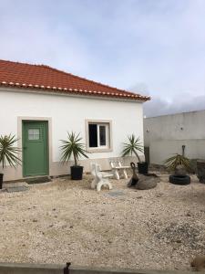 a white building with a green door and some plants at Consciência Viva in Encarnação