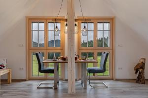 a dining room with a table and chairs and windows at Wallemehof in Wolfach