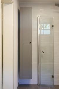 a walk in shower with a glass door at Ferienwohnung Tromei-Hof in Oberderdingen
