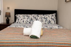 a bed with two rolled towels on top of it at RB home Stockport in Stockport