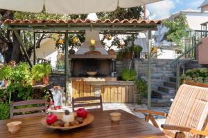an outdoor patio with a table and a fireplace at Nontas Home 27 in Kalamitsi