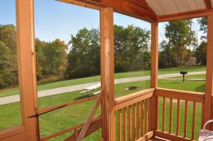 a screened in porch with a view of a park at Plymouth Rock Camping Resort Deluxe Cabin 16 in Elkhart Lake