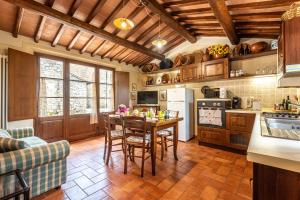 a kitchen with a table and chairs in a room at La Casa Di Emma in Gaiole in Chianti +18 photos