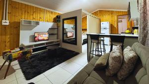 ein Wohnzimmer mit Couch und Küche in der Unterkunft Apartamento no Centro de Gramado, 700 m da Rua Coberta in Gramado