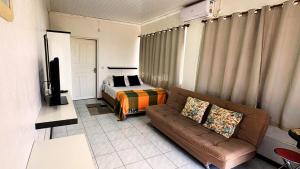 ein Wohnzimmer mit einer Couch und einem Bett in der Unterkunft Apartamento no Centro de Gramado, 700 m da Rua Coberta in Gramado