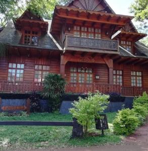 a large wooden house with a balcony on top at Departamentos Don Julio in Guaraní