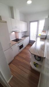 eine Küche mit weißen Schränken und einem Holzboden in der Unterkunft Apartamento San Juan in Casas-Ibáñez