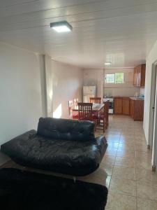 a living room with a leather couch and a kitchen at Departamentos Don Julio in Guaraní