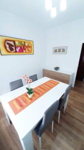 einen weißen Esstisch mit Stühlen und ein Gemälde an der Wand in der Unterkunft Apartamento San Juan in Casas-Ibáñez
