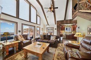 a living room with leather furniture and large windows at Four Diamond Escape in Seven Devils
