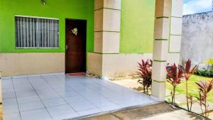 um edifício verde e branco com uma porta em Bem vindos ao paraíso de Genipabu! em Extremóz mais 3 fotografias