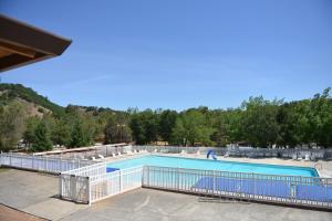 een groot zwembad met een hek eromheen bij Morgan Hill Camping Resort Cottage 3 in San Martin