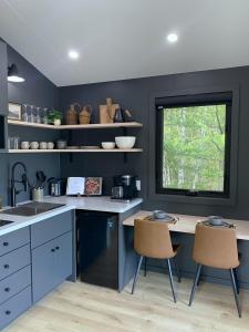 a kitchen with blue walls and a table and chairs at Coastal A-Frame, Near Schoodic Point, Acadia in Gouldsboro