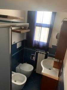 a small bathroom with a toilet and a sink at Casa con giardino in Lido delle Nazioni
