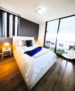 a bedroom with a large bed and a large window at Stadium Retreat in Sydney
