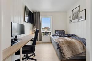a bedroom with a bed and a desk with a computer at Modern apartment in Elverum in Elverum