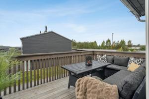 a patio with a couch and a table on a deck at Modern apartment in Elverum in Elverum