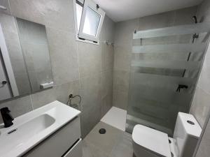 a bathroom with a sink and a toilet and a mirror at Monte Paraíso Beach in Puerto Rico de Gran Canaria +6 photos