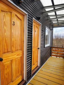 a house with wooden doors and a wooden walkway at Micha Loft in Puerto Natales +13 photos