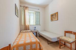 アウグスタにあるCasa Nicoのベッドルーム1室(ベッド1台、ベンチ、窓付)