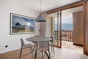 a dining room with a table and chairs and a balcony at Maso Renner in Laives