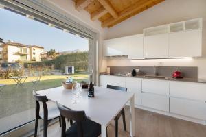 a kitchen with a white table and a large window at Little Mier Iseo in Iseo