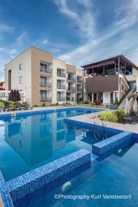 KoforiduaにあるAIDEN HOMES AND APARTMENTS HOTElの建物の前の大きなプール