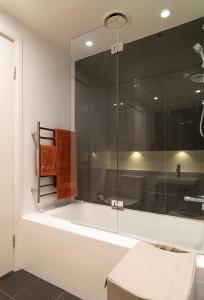 een badkamer met een bad en een glazen douche bij Stadium Retreat in Sydney