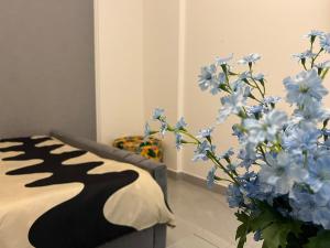 Karama pretty unit near metro في دبي: غرفة بها أريكة ومزهرية من الزهور الزرقاء