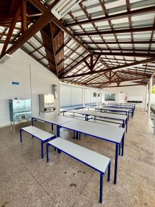 a row of blue tables in a room at Hostel Oficial COP30 in Belém