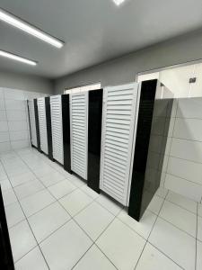 a row of lockers in a bathroom with white tiles at Hostel Oficial COP30 in Belém