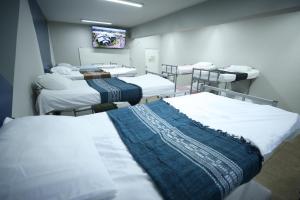a hospital room with several beds and a tv at Hostel Oficial COP30 in Belém