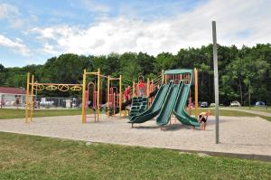 a playground with a slide in a park at Plymouth Rock Camping Resort Two-Bedroom Park Model 9 in Elkhart Lake