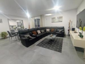 a living room with a black leather couch and a table at Villa Luz 37 - Jacuzzi Terrace & Swimming Pool in Albufeira +63 photos