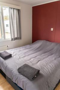 a bedroom with a bed with two towels on it at Chalet Koolmees in Anloo +6 photos