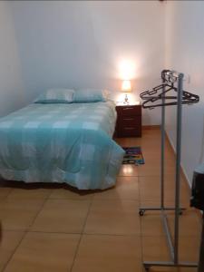 ein Schlafzimmer mit einem Bett und einer Lampe auf dem Boden in der Unterkunft Pernoctancia in La Pampilla