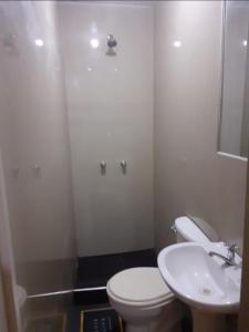 ein Badezimmer mit einer weißen Toilette und einem Waschbecken in der Unterkunft Pernoctancia in La Pampilla